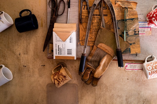 A work table covered in tools and one well-worn Vermont Glove work glove
