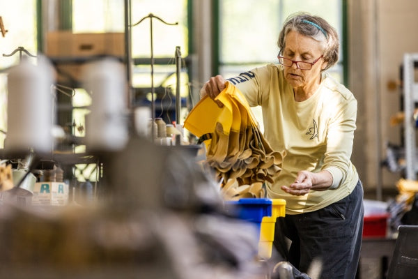 An employee lifting cut leather pieces