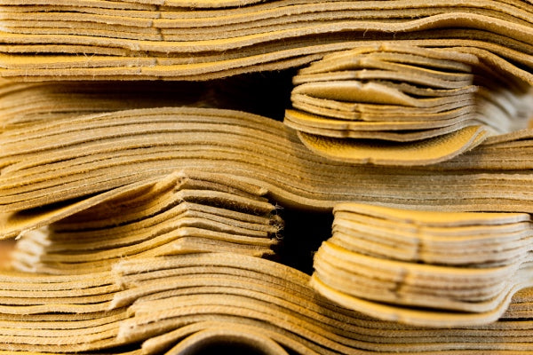 A stack of cut leather, ready to be sewn into gloves