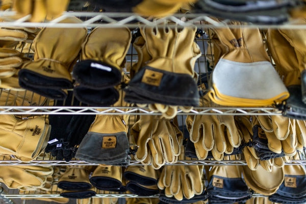 Rows of leather Vermont Gloves on racks
