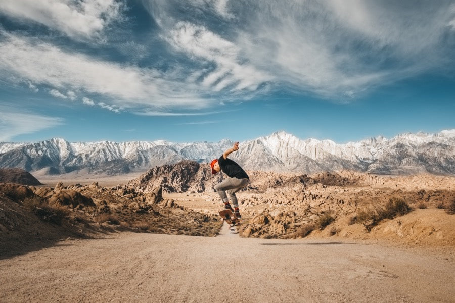 Skateboarder doing a trick with mountains in the background wearing darn tough socks