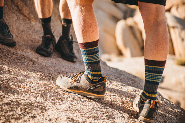 Hiker on rocks wearing breathable merino wool socks