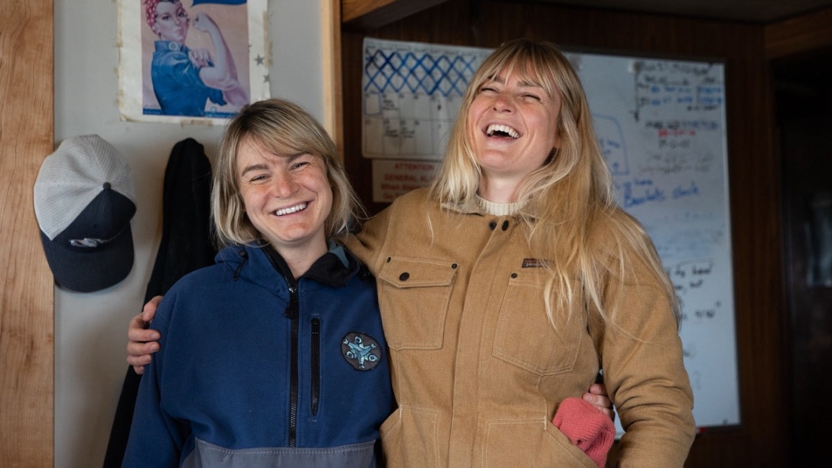 The Salmon Sisters, Emma and Claire, smiling and laughing while hugging each other