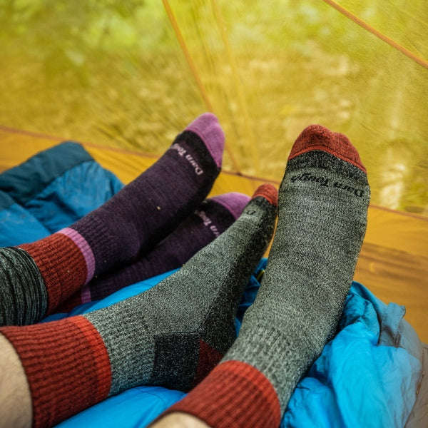 Backpackers in their tent, shoes off, wearing super soft twisted yarn socks