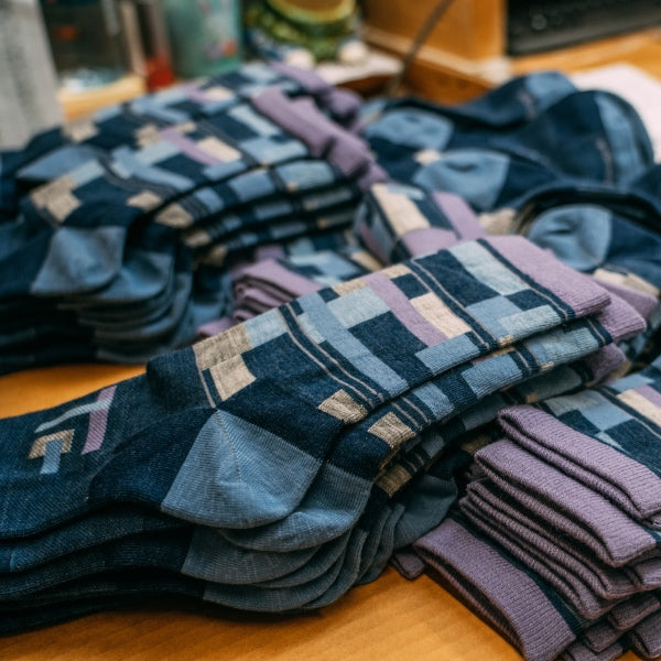 Piles of the best fitting socks, made by Darn Tough, ready to be packaged and shipped