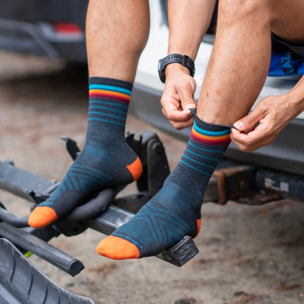 Runner seated on tailgate wearing darn tough socks with performance fit, like a second skin