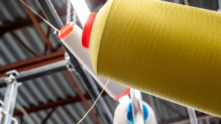 A cone of Merino Wool yarn at the Darn Tough Mill, showing how thin the threads are