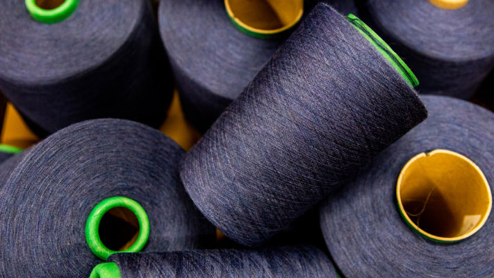 Several cones of merino wool yarn in navy blue