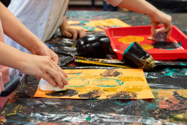 Student pressing onion onto paper to create a cool texture