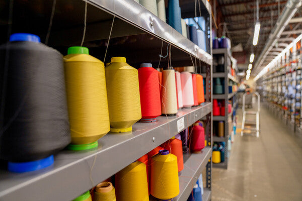 Rows and rows of merino wool yarn cones at Darn Tough's mill