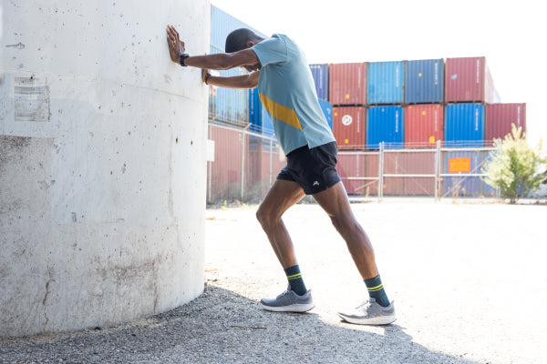 Runner pressing against a wall to stretch before heading out