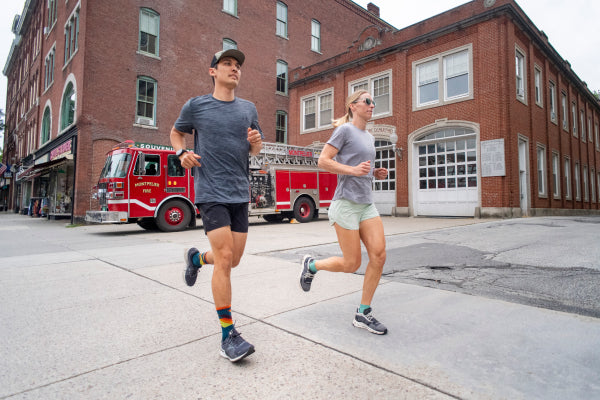 Two runners headed down the streets of a city