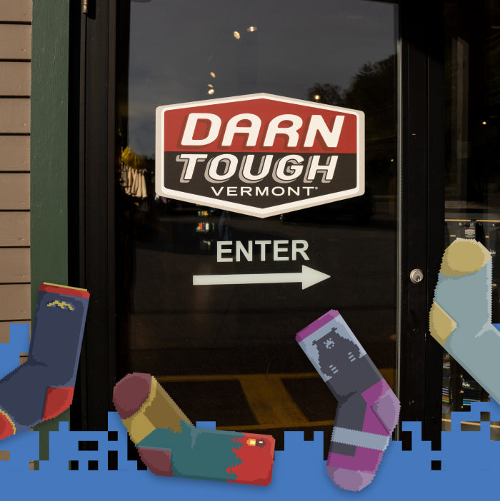 A Darn Tough retailer door inviting you to enter, with bitmap socks floating around it