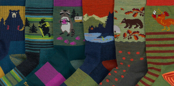 Six different sock patterns from Darn Tough, featuring bears, raccoons, and more