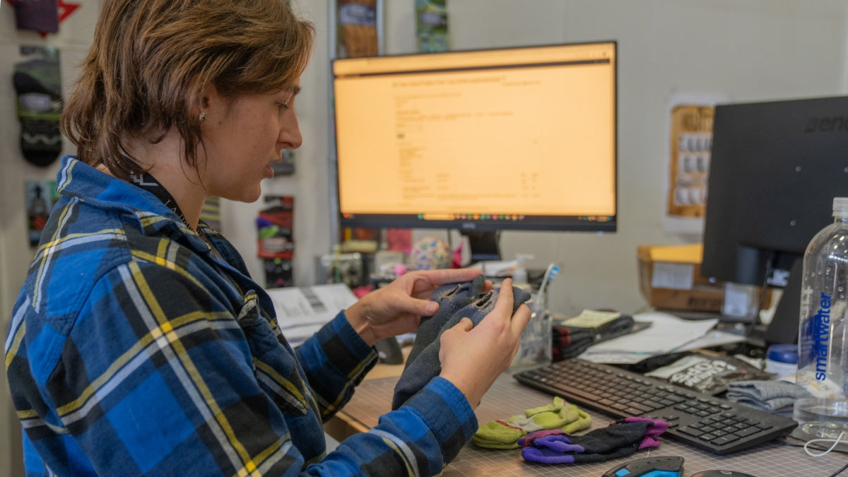 Warranty team member inspecting a returned sock