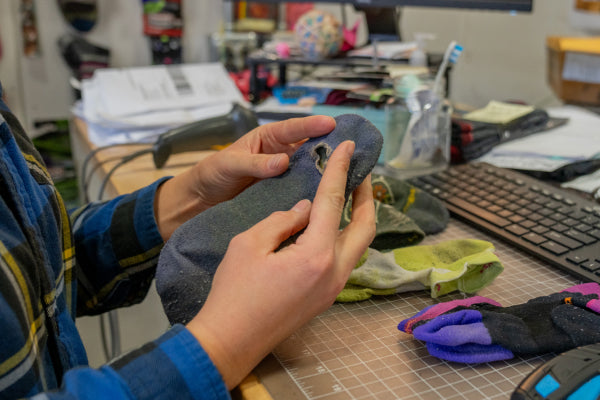 Closeup of hands holding a warrantied sock, inspecting it