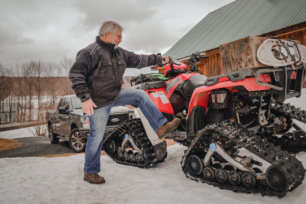 Farmer getting onto a snow quad