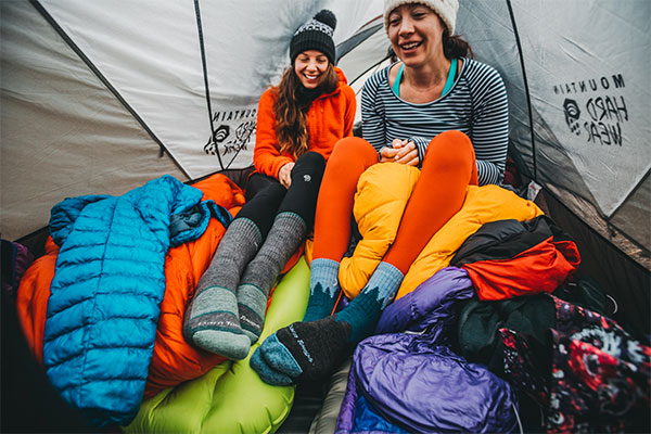 Two hikers in tent wearing darn tough merino wool hiking socks