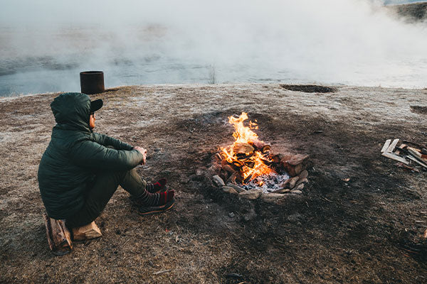 Man in merino wool socks by fire, the perfect socks for cold weather