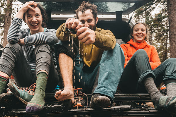 Hiker wringing out his merino wool socks after fully submerging in water