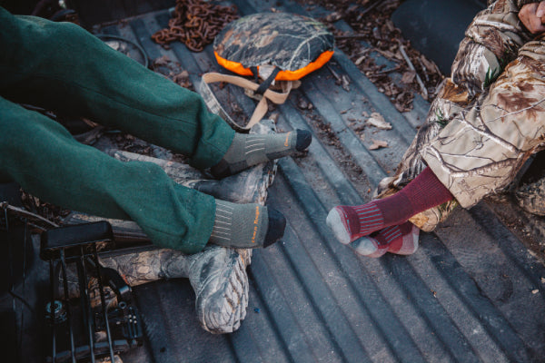 Hunters sitting in the bed of a truck in their Darn Tough Hunt Socks