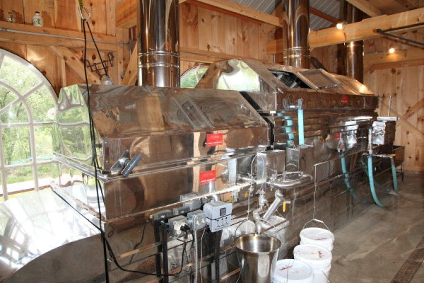 The inside of a maple syrup sugar shack, with large machines and tanks