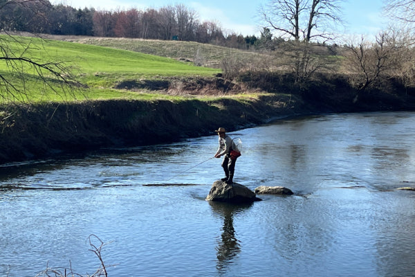 Kevin casting in the middle of a river