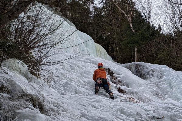 Kevin climbing up a wall of ice