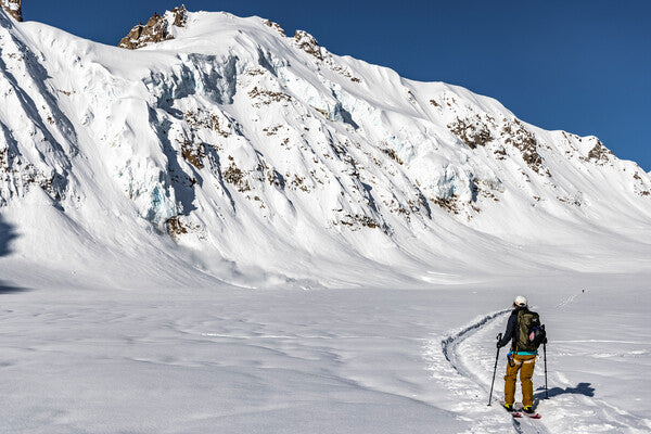 Michelle Parker skiing out toward a dramatic mountain Ridgeline