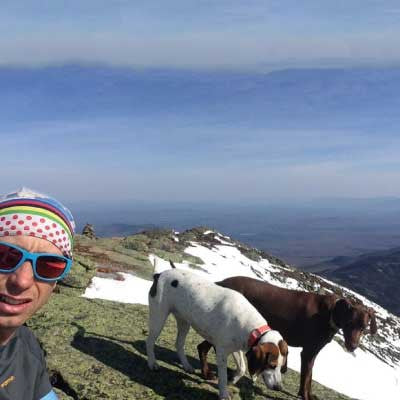 Josh sitting on the summit with his two dogs