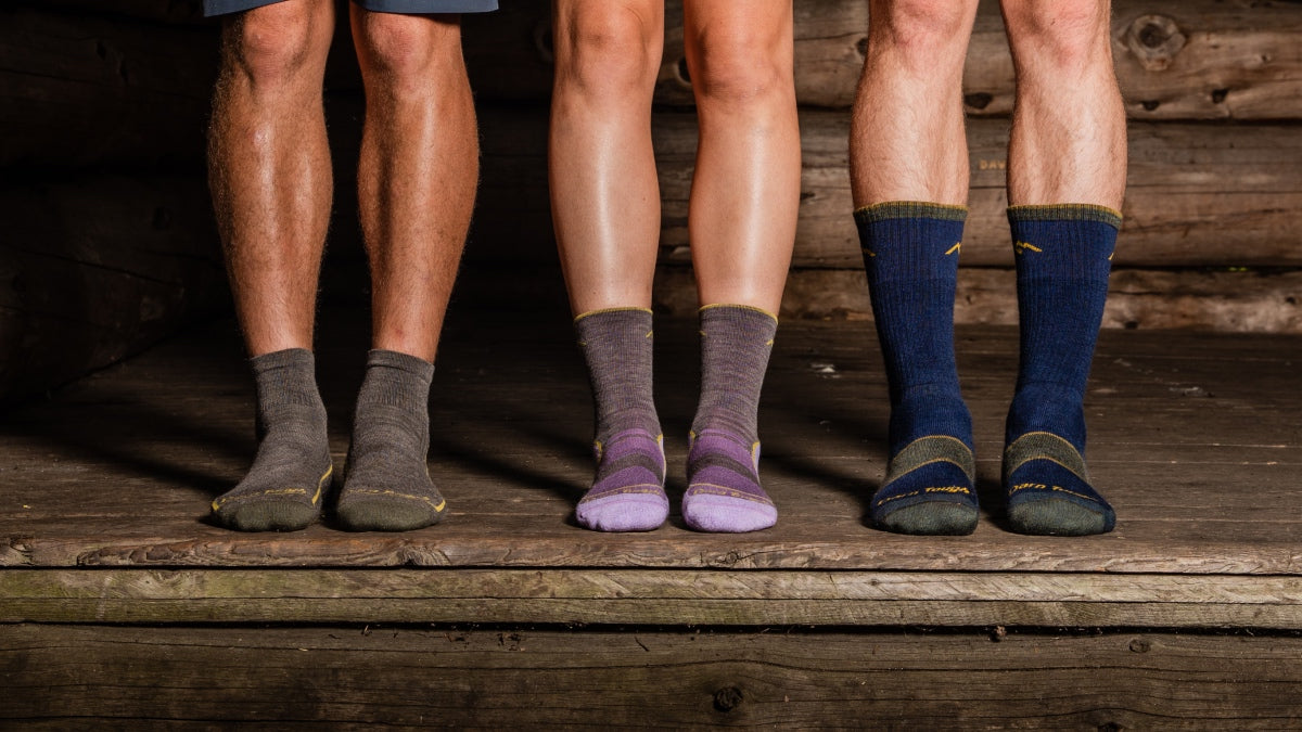 Three people in darn tough socks with different heights but the same performance fit