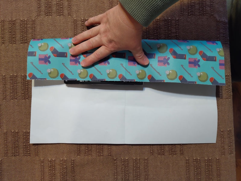Socks on a cut piece of wrapping paper, folding the long edge over the socks