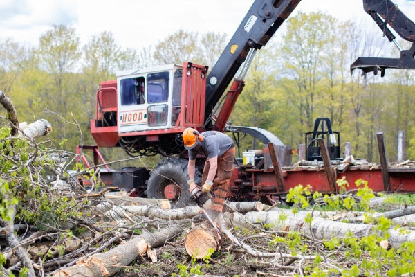 Man and tractor out cleaning land wearing Vermont Gloves