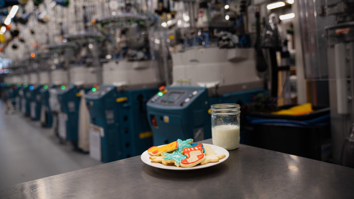 A plate of sock-shaped Christmas cookies and glass of milk left out at Darn Tough's Mill