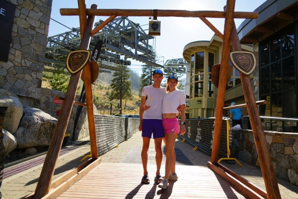 Andy and his wife standing under the cowbell at the finish line