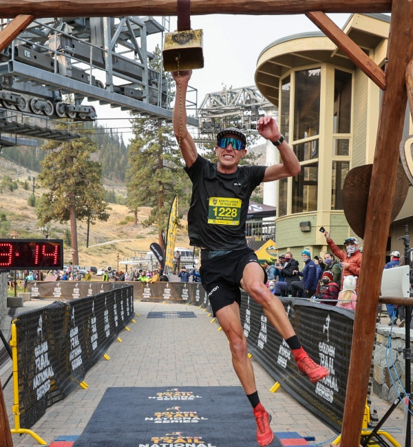 Andy jumping up to ring the cowbell because he finished the race