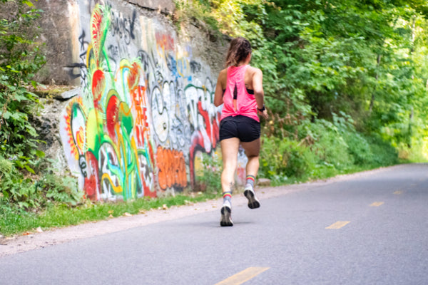 Person running on a road in Darn Tough socks