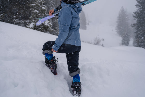 Model walking through deep snow with Ski Boots and Darn Tough Socks