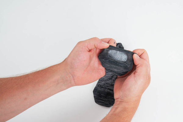 Hands turning no show hidden socks inside out to show silicone grip strip to prevent slipping