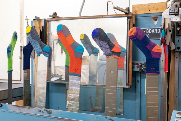 A bunch of brightly colored overstock socks getting boarded