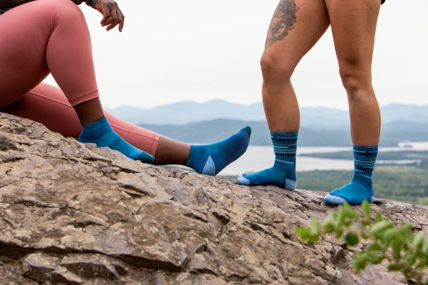 Two runners standing on mountain together