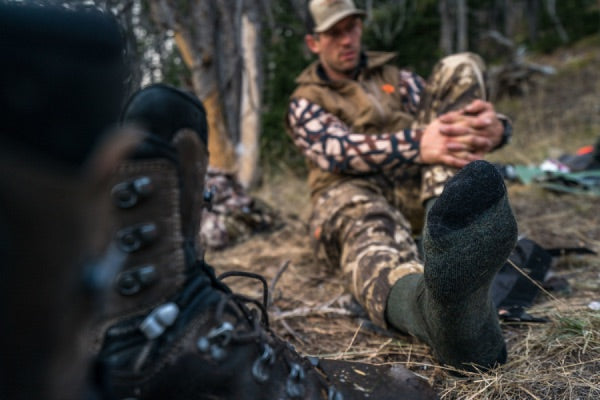 Hunter seated outside in darn tough hunting socks
