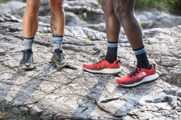Two runners, one wearing padded socks and one wearing socks with no cushion