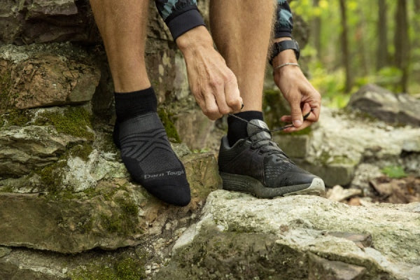 Josh putting on running shoes over black running socks