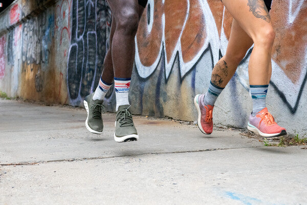 Two runners wearing the Pacer running sock with a tortoise and hare design