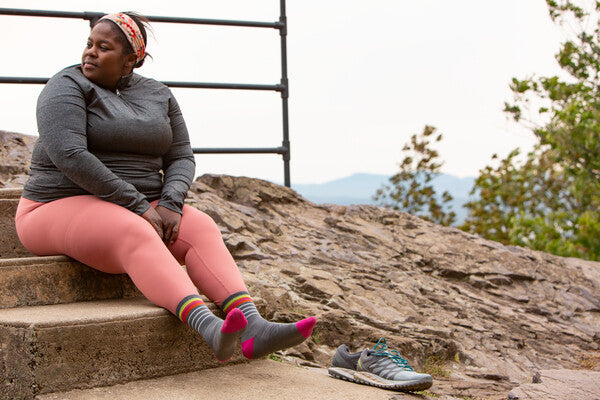 Ultra runner Mirna Valerio seated on summit after trail running