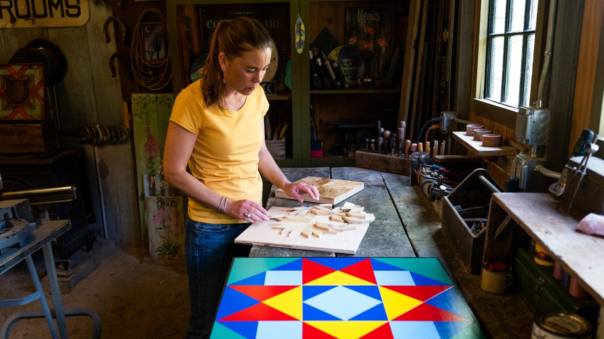 Megan making a Barn Quilt with the Knit to Give inspired Barn Quilt next to her