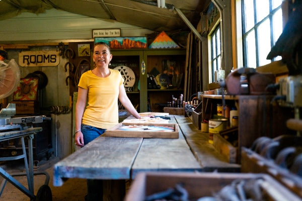 Megan smiling while standing at her workbench