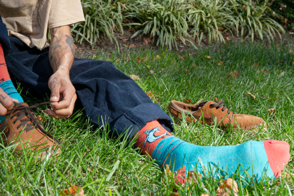 Person putting on dress shoes over super colorful dress socks