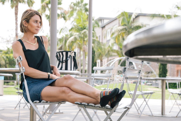 Person seated on patio with feet up wearing no show casual socks